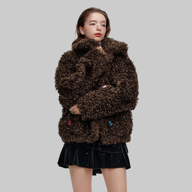 chica con minifalda con abrigo marrón de franela oversize con ositos tipo gominola cosidos